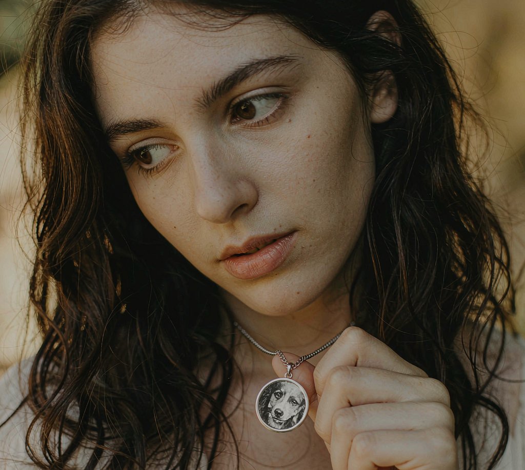 A woman wearing a photo keepsake pendant of her dog